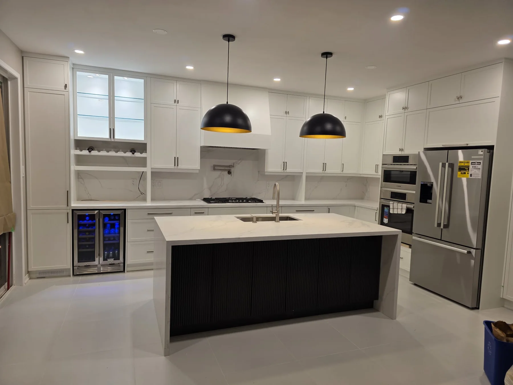 Completed white kitchen renovation with custom cabinetry and a contrasting dark island